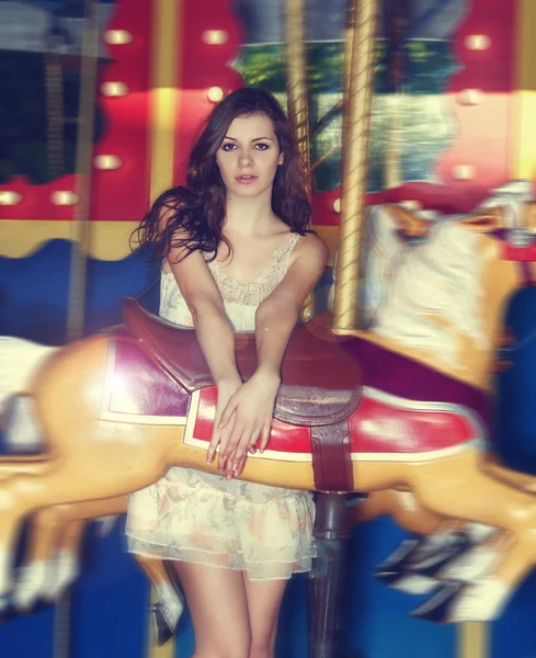 Fashion model posing on merry-go-round carousel — Stock Photo, Image