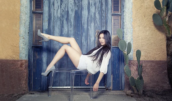 Gyönyörű fiatal ázsiai divat modell pózol a szék — Stock Fotó
