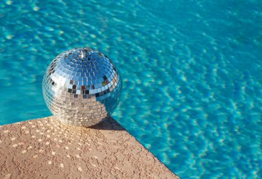 Disco ball beside swimming pool clipart