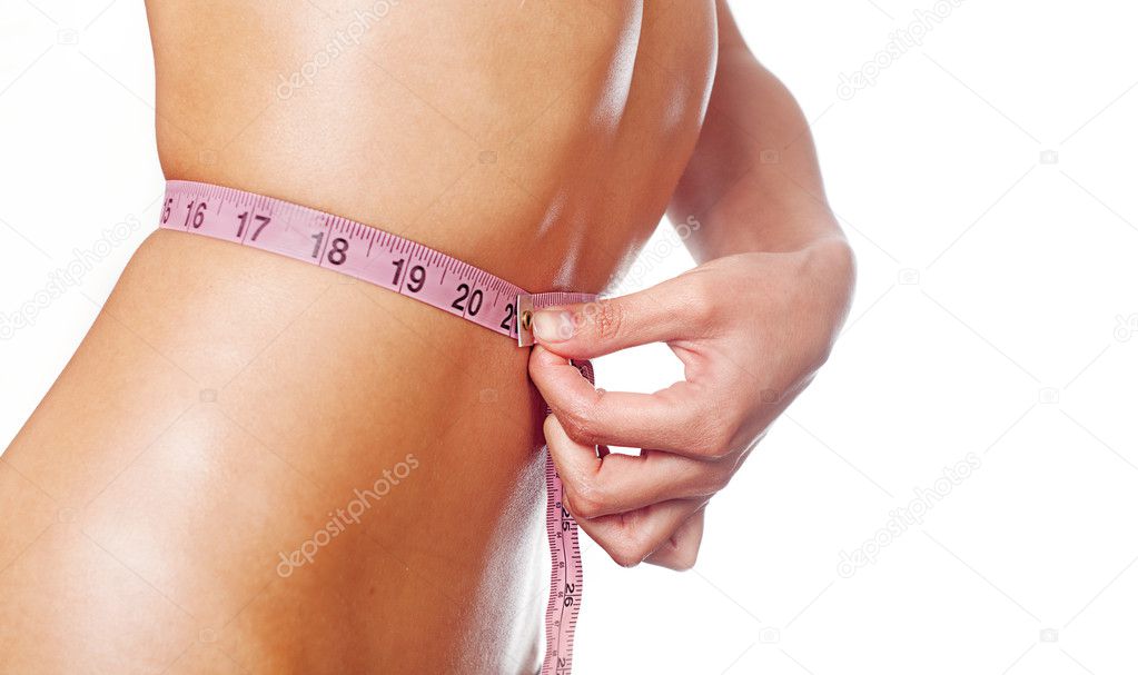 Slim young woman measuring waist.