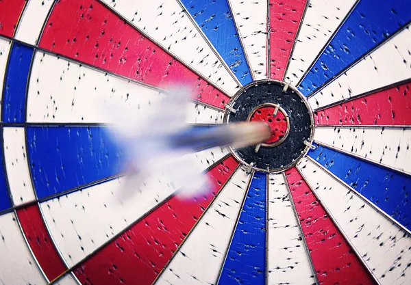 Dart in motion hit bullseye — Stok Foto