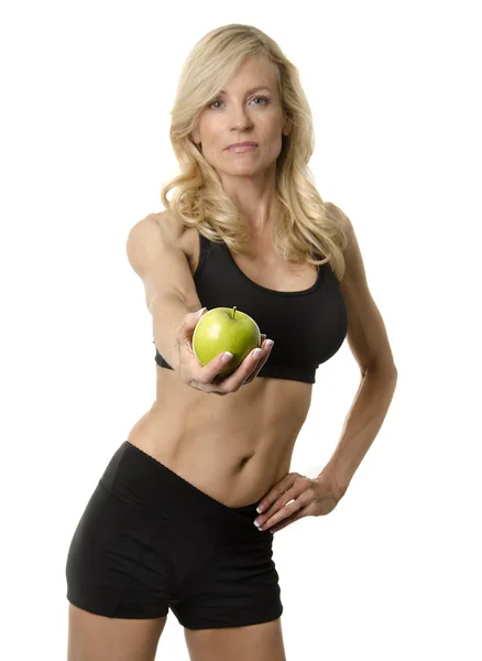 Frau im Fitness-Trainingsanzug hält Apfel. — Stockfoto