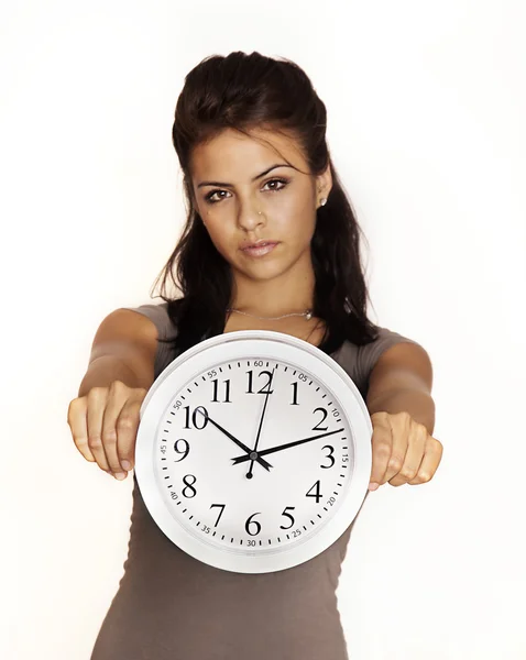 Ung kvinna som håller en klocka. Stockbild