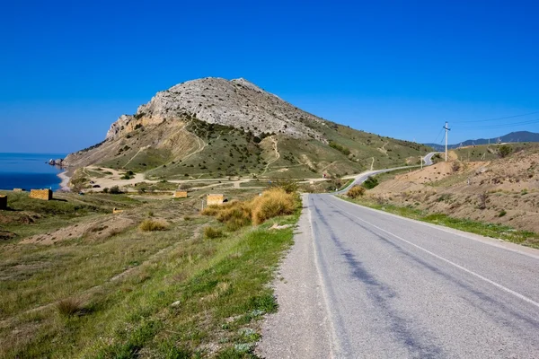Camino de asfalto en un valle montañoso — Foto de Stock