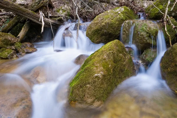 A água que corre sobre umas pedras — Fotografia de Stock