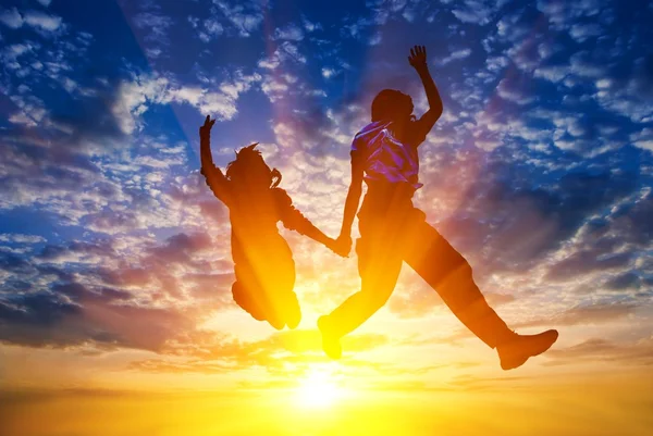 Peoples silhouette jumping on a sunset background — Stock Photo, Image