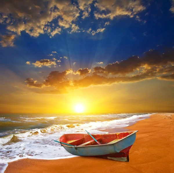 Liten båt på en havet kusten vid solnedgången — Stockfoto