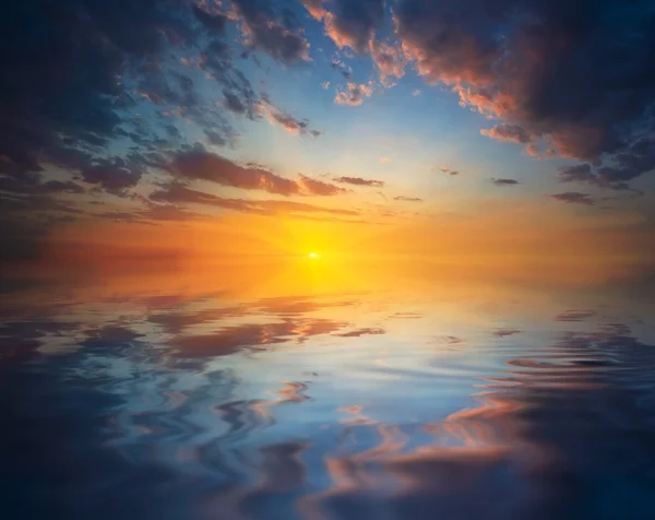 Puesta de sol reflejada en un agua — Stok fotoğraf