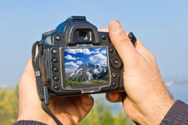 elinde bir dijital fotoğraf makinesi