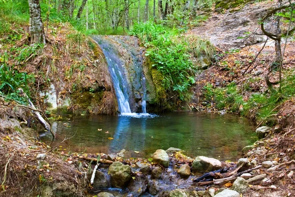 Wasserfall und kleiner See in den Bergen — Stockfoto