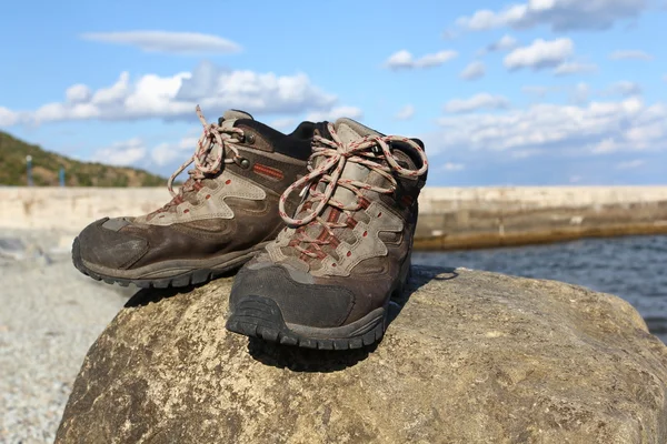 Buty turystyczne na kamieniu w pobliżu wybrzeża Morza — Zdjęcie stockowe