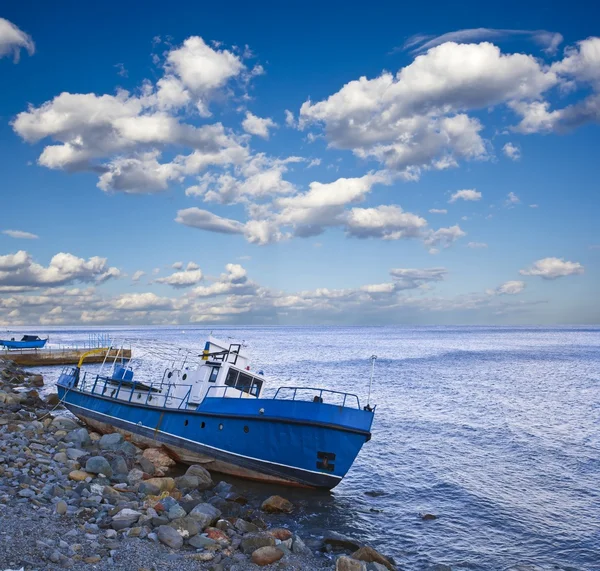 Брошенная лодка на морском побережье — стоковое фото