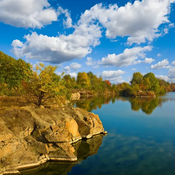Lac avec littoral rocheux au jour d'automne — Photo