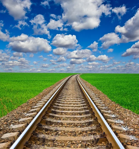 Chemin de fer partant loin parmi des champs verts — Photo