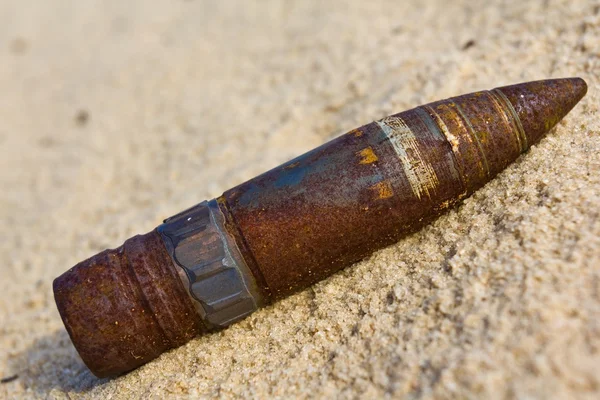 Vecchio proiettile arrugginito su una sabbia — Foto Stock