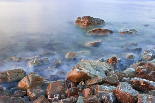 Stenen op een zeekust door een ochtend — Stockfoto