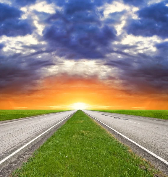 Dvě cesty asfaltové silnici na západ slunce — Stock fotografie