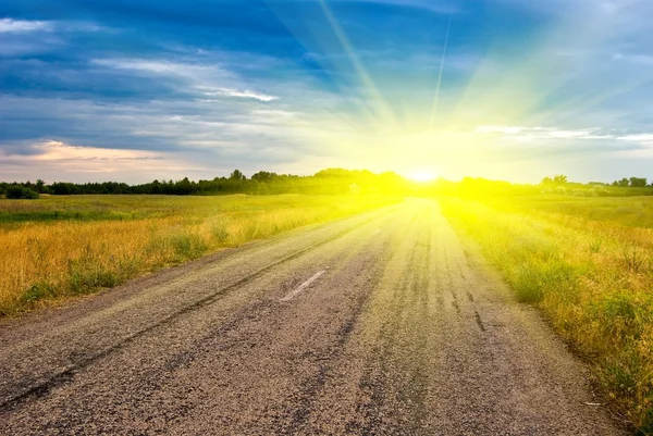 Pôr-do-sol dramático e estrada de asfalto — Fotografia de Stock