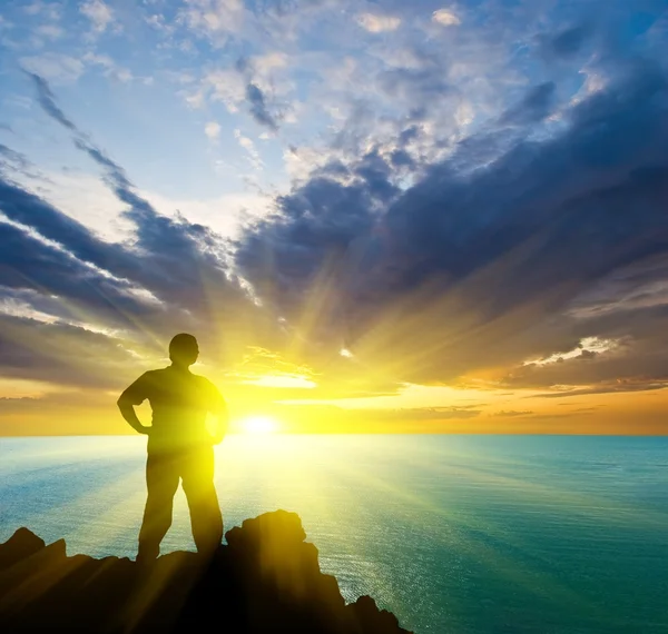 Az ember marad a tengeri-köpeny a naplementekor — Stock Fotó