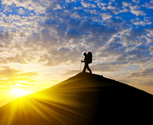 Silhueta de viajante no topo de uma montanha ao pôr do sol — Fotografia de Stock