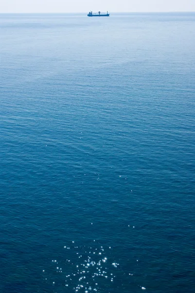 Летнее море и грузовое судно далеко — стоковое фото