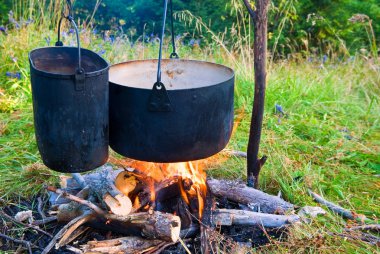 Two touristic cauldron in a fire clipart