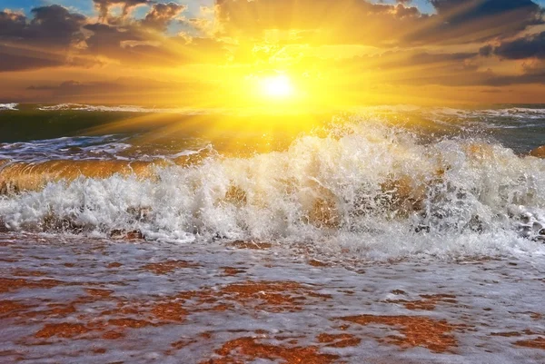 Pôr-do-sol dramático em uma costa de mar tempestuoso — Fotografia de Stock