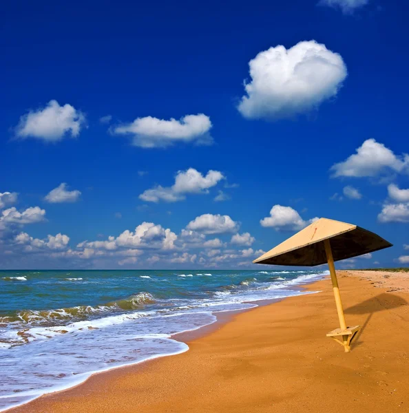 Зонтик на летнем морском пляже — стоковое фото