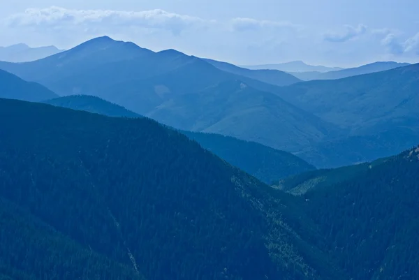 Montanhas silhueta em uma névoa azul — Fotografia de Stock