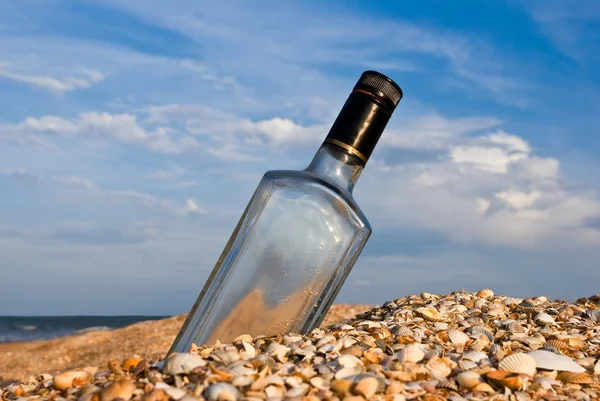 Бутылка в песке на морском побережье — стоковое фото