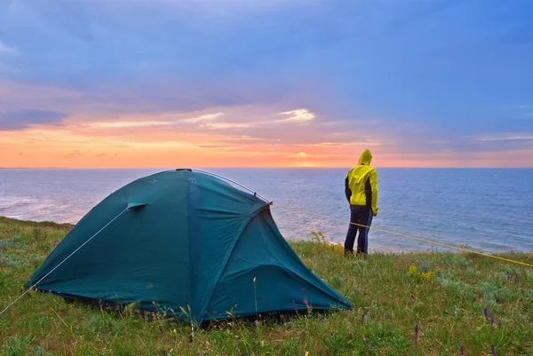 Tourist near a tent by an evening — Stock Photo, Image