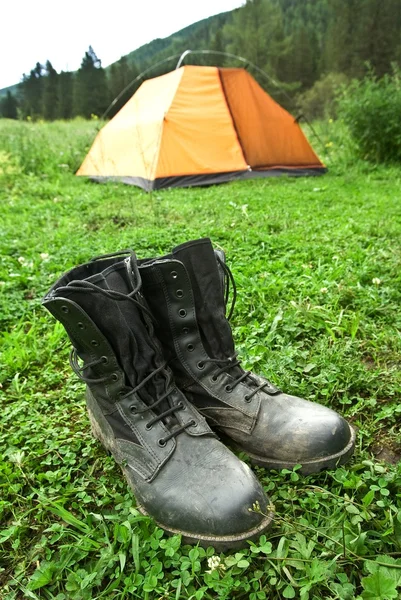 Ботинки охотников возле палатки — стоковое фото