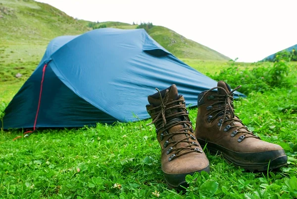Stivali Tourictic vicino a una tenda su un'erba — Foto Stock
