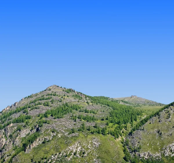Montanha verde em um fundo céu azul — Fotografia de Stock