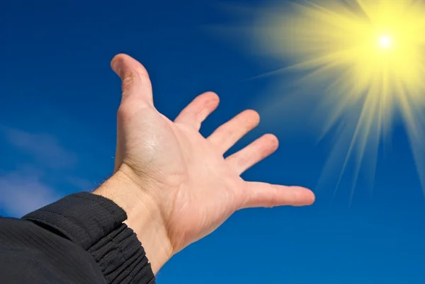 stock image Hand reaches for the sun