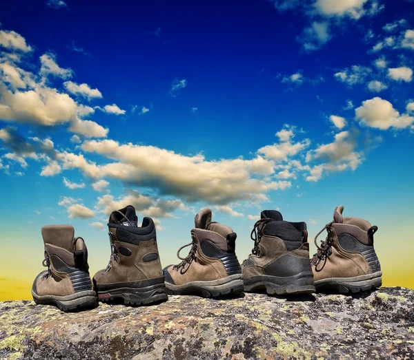 Туристический ботинок на скале на фоне неба — стоковое фото