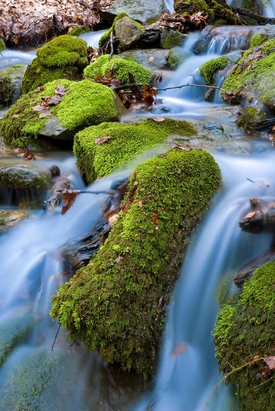 A água de close-up que corre sobre umas pedras — Fotografia de Stock