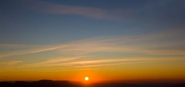 Puesta de sol en un panorama de montañas — Foto de Stock