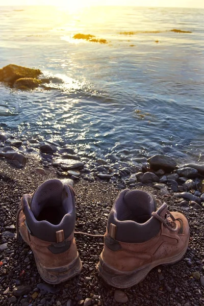 Touristic boots on a sea coast at the early morning — Stock Photo, Image
