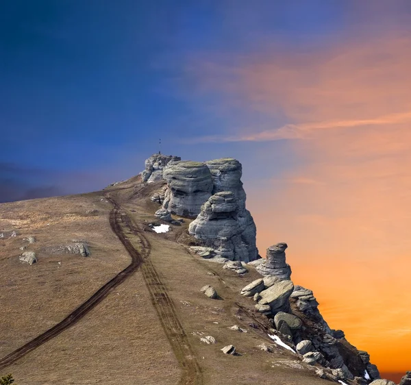 Kayanın üzerinde bir akşam gökyüzü arka plan — Stok fotoğraf