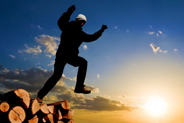 Jumping silhouette on a sunset background — Stock Photo, Image