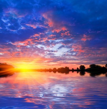 Dramatic red and blue evening clouds reflected on a water clipart