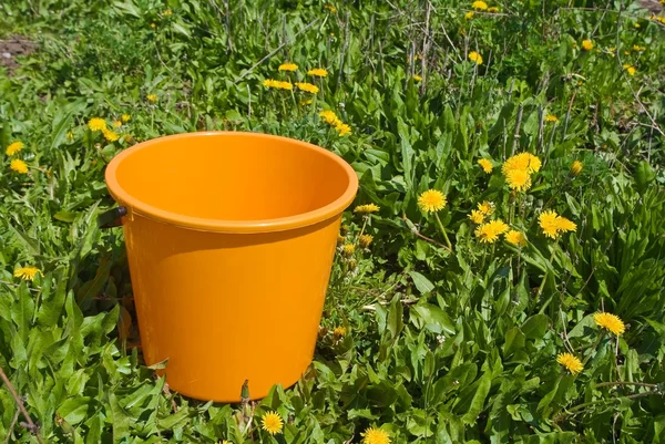 Orange bucket in a grass — Stock Photo, Image