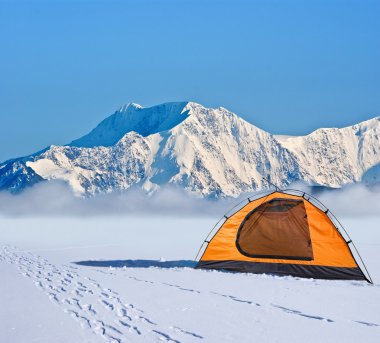 Orange touristic tent before ice wall clipart