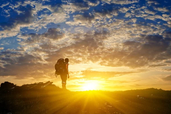 Hiker in a mountains at the sunset — Stock Photo, Image