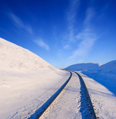 Winter railway among a snowbound fields clipart