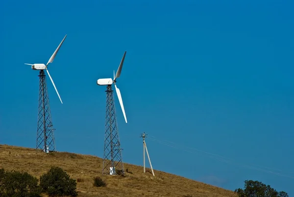 Dwóch turbin wiatrowych na zboczu wzgórza — Zdjęcie stockowe