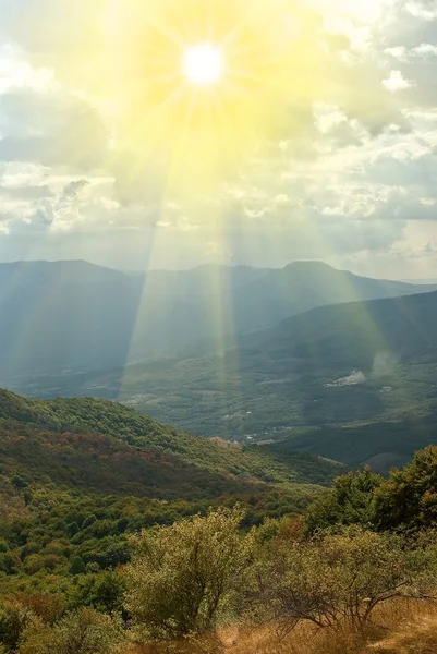 bir dağ üzerinde güneş parlıyor