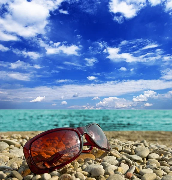Óculos de sol em uma praia — Fotografia de Stock