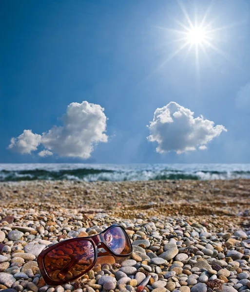 Gafas de sol en la orilla del mar — Foto de Stock